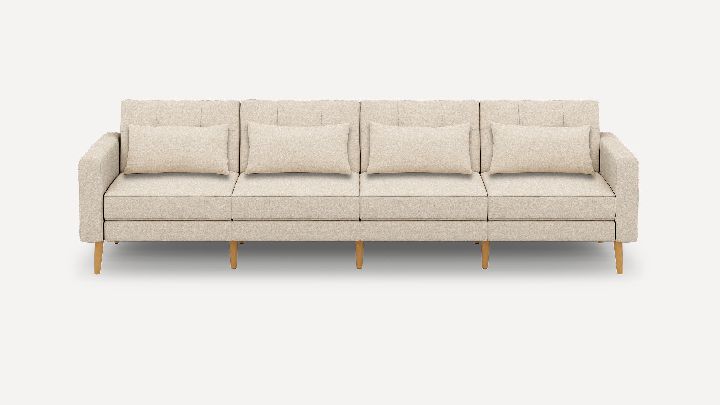 Beige four-seater modern sofa with wooden legs and four matching rectangular cushions on a plain white background.