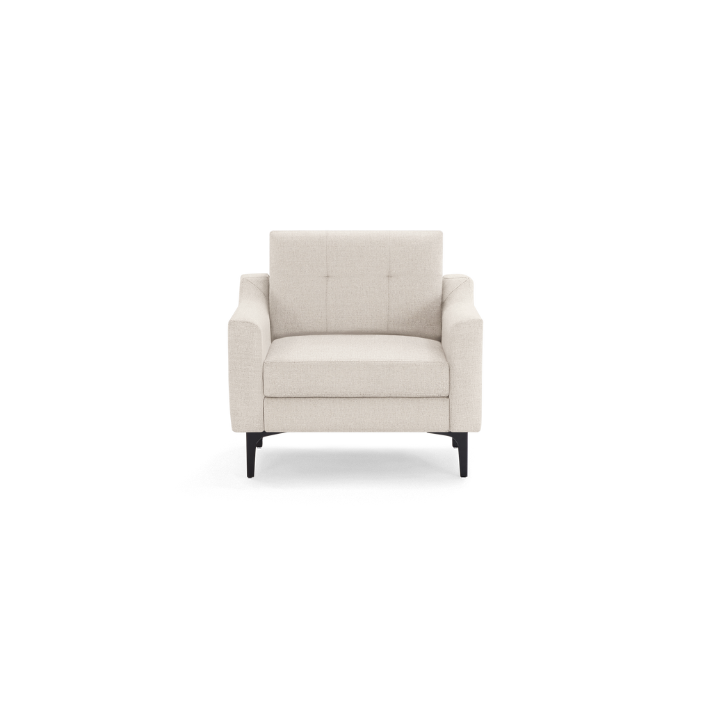 Modern beige fabric armchair with tufted backrest, wide armrests, and black angled wooden legs against white background.