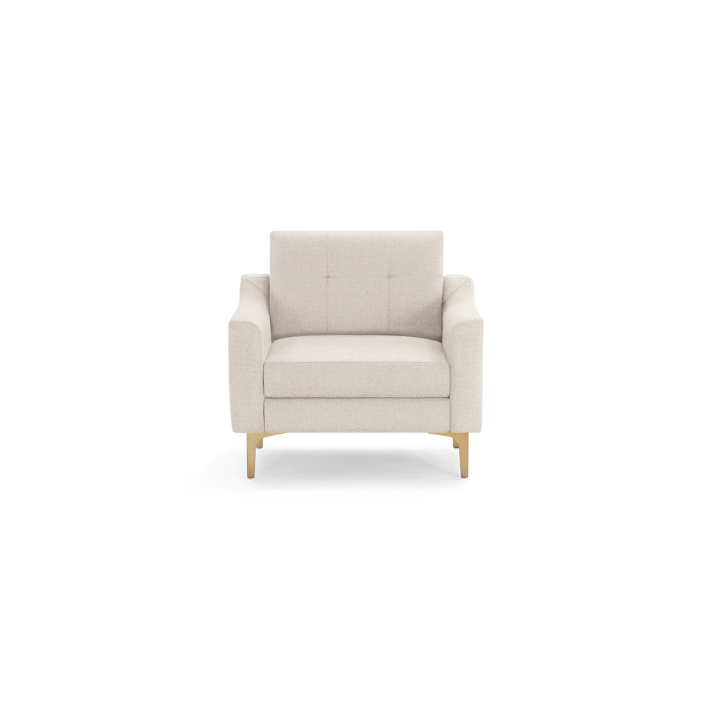 Modern beige upholstered armchair with tufted backrest, straight arms, and light wooden legs on black background.
