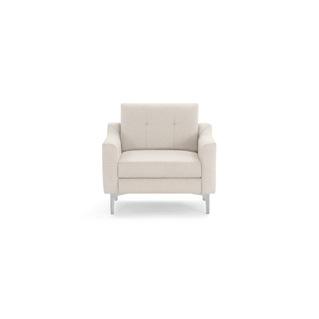Modern beige upholstered armchair with clean lines, tufted backrest, wide armrests, and sleek silver metal legs, isolated on black background.