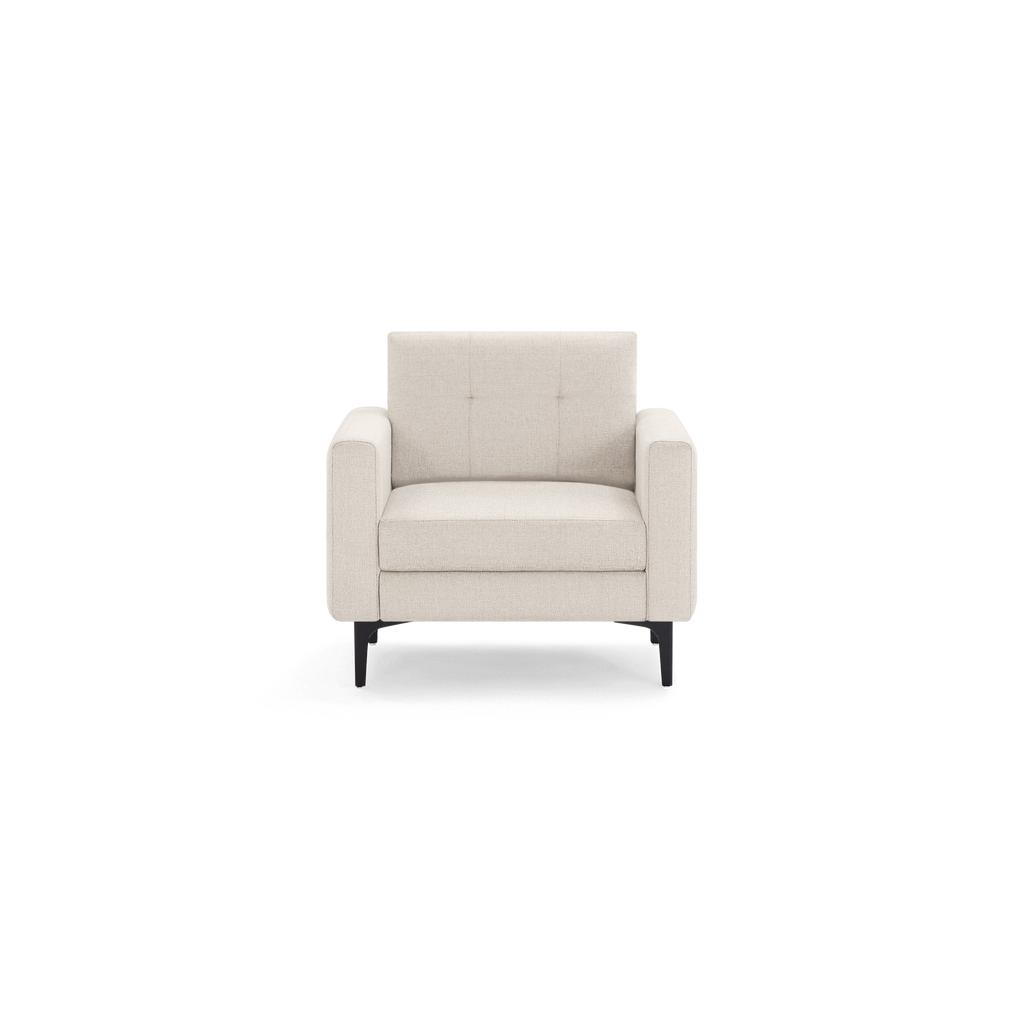 Cream-colored modern armchair with tufted backrest, cushioned seat, wide padded armrests, and black metal legs.