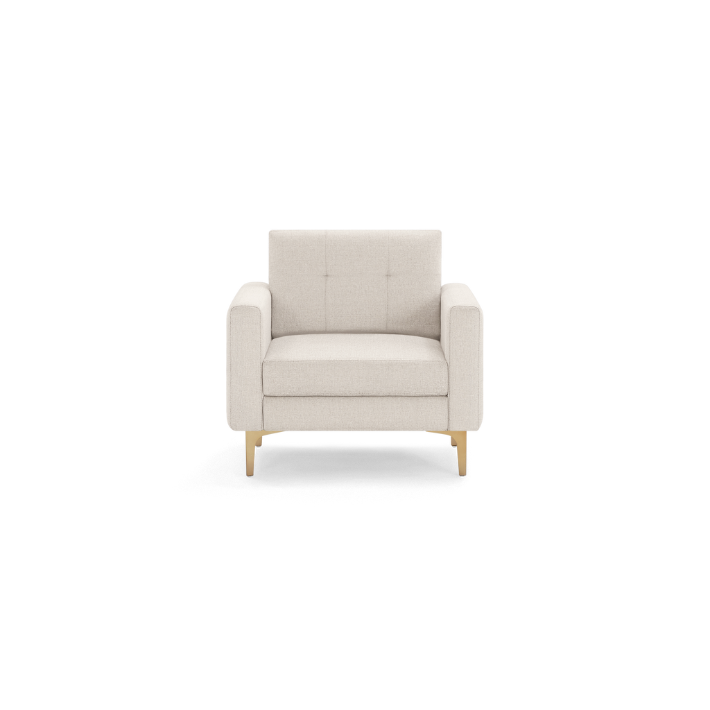 Beige upholstered armchair with square arms, tufted backrest, cushioned seat, and light wooden legs.