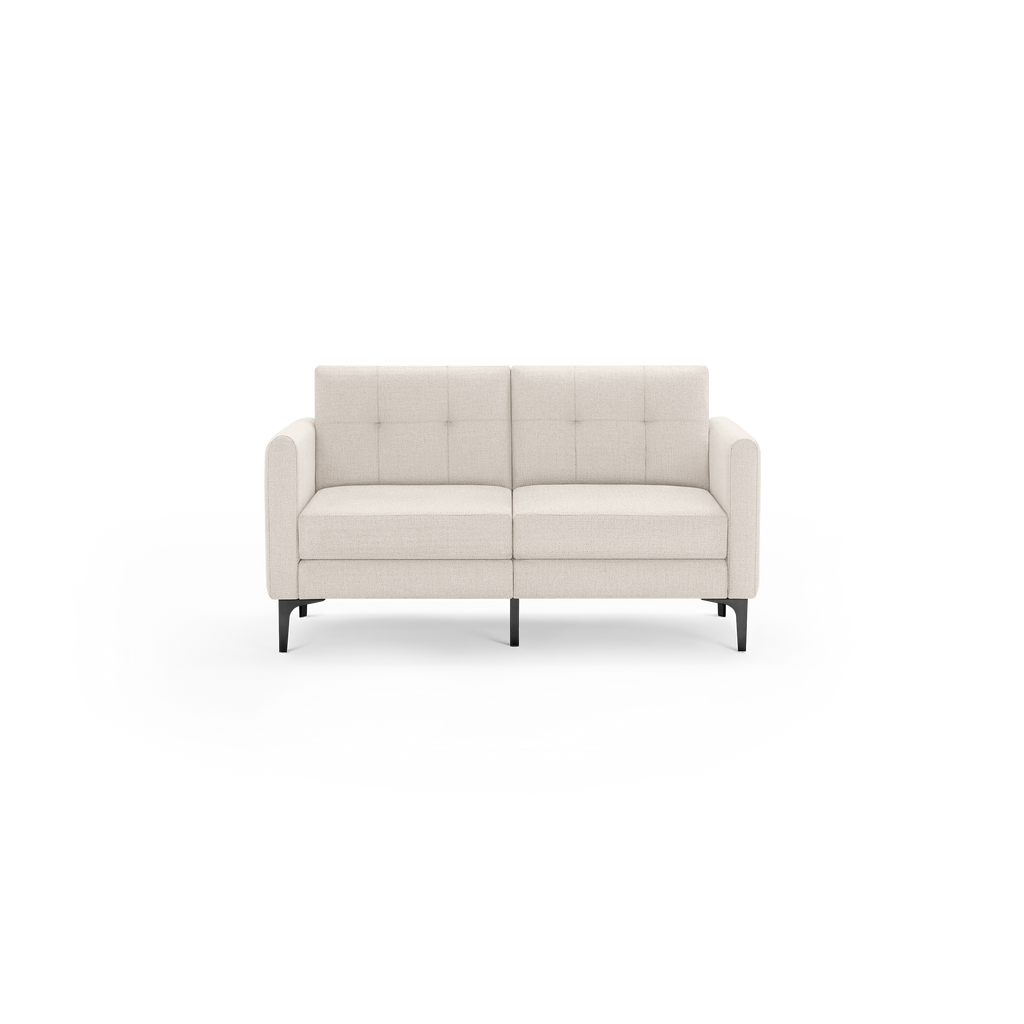 Modern two-seater beige fabric sofa with tufted backrest, high armrests, and black metal legs, isolated on black background.