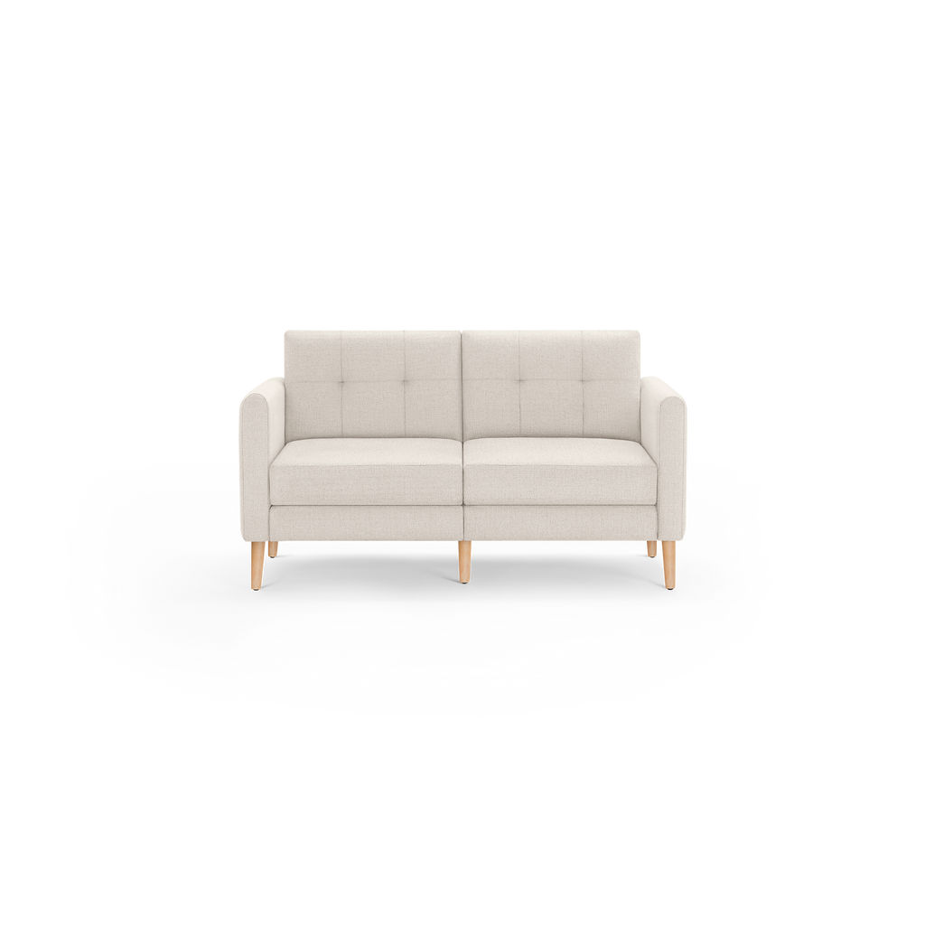 Two-seater beige fabric sofa with button-tufted backrest and light wooden legs, modern minimalist design.