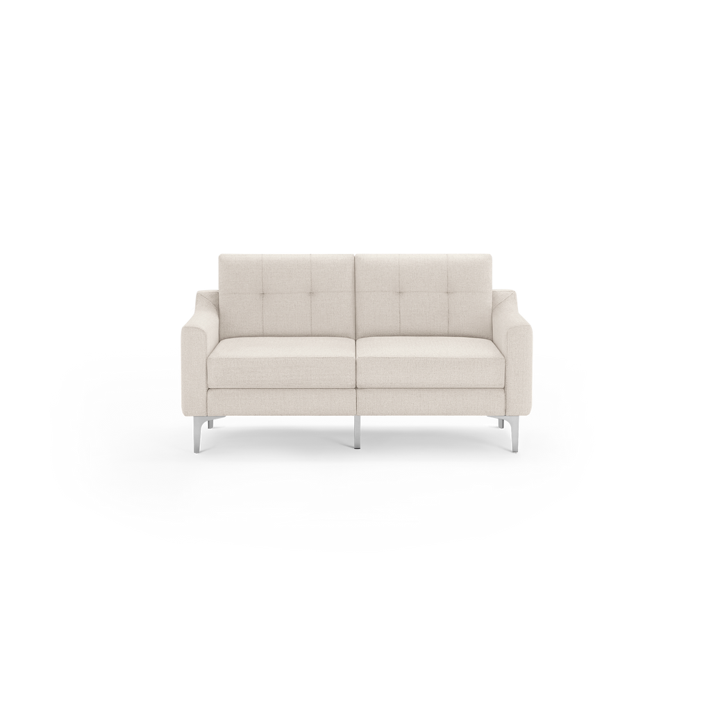 Beige two-seater sofa with cushioned seats and backrests, featuring tufted upholstery and modern metal legs.