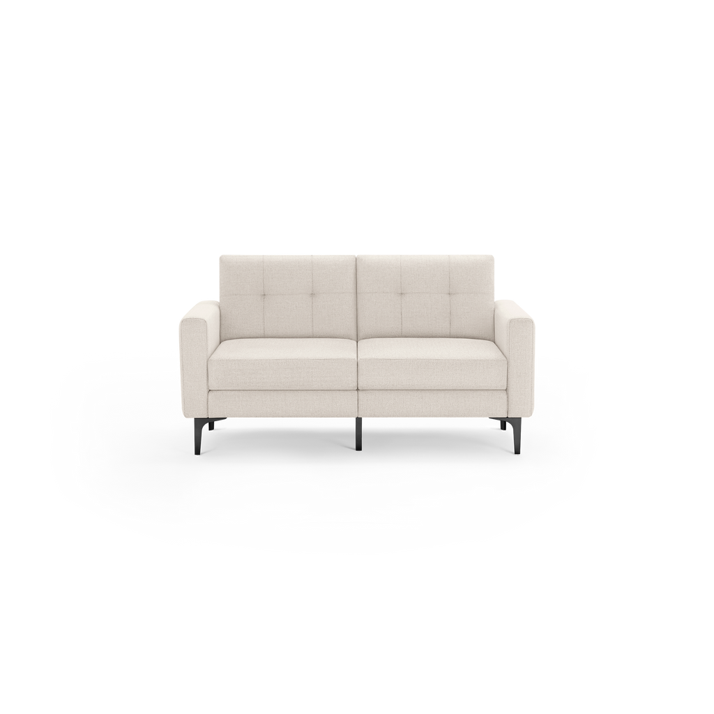 Modern beige two-seater sofa with tufted back cushions, straight armrests, and black metal legs, isolated on black background.
