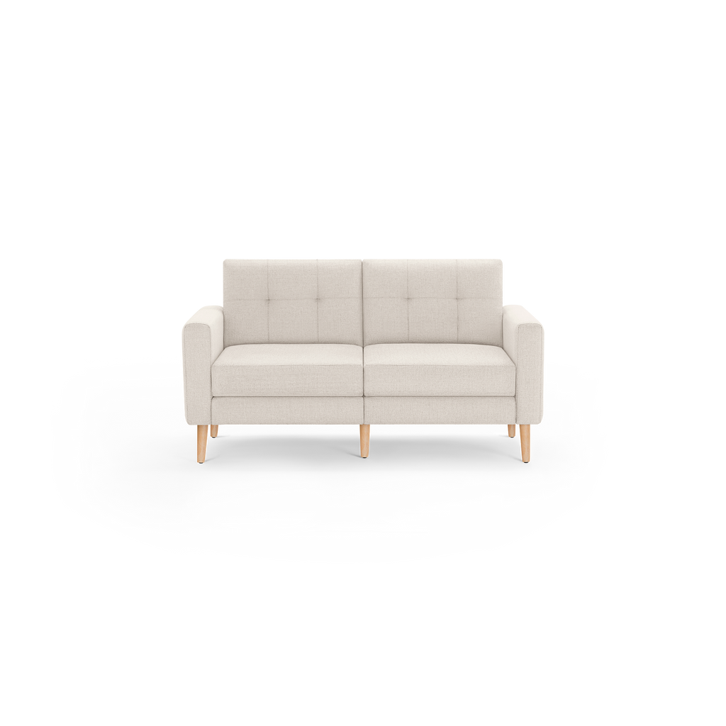 Beige two-seater sofa with tufted backrest, cushioned seats, straight armrests, and light wooden legs against a white background.