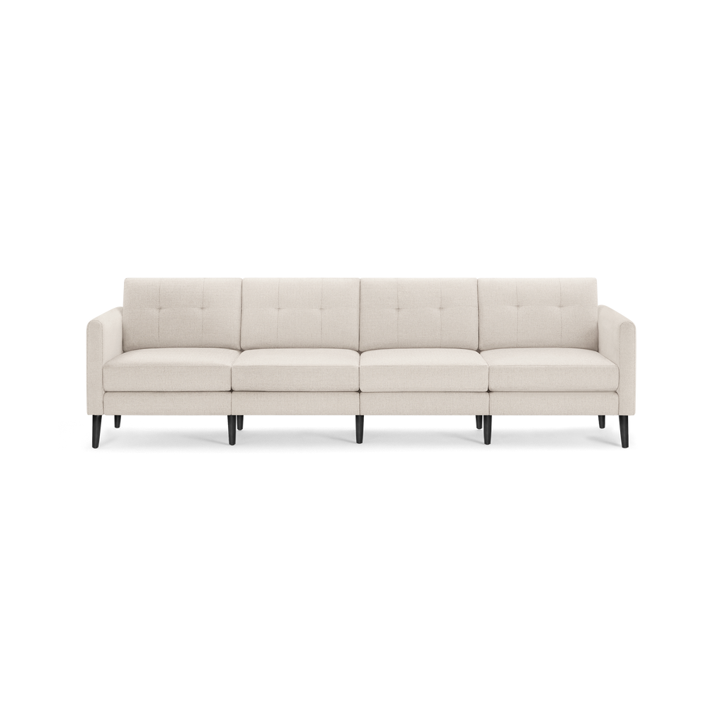 Cream-colored four-seat modern sofa with tufted back cushions and black tapered wooden legs.