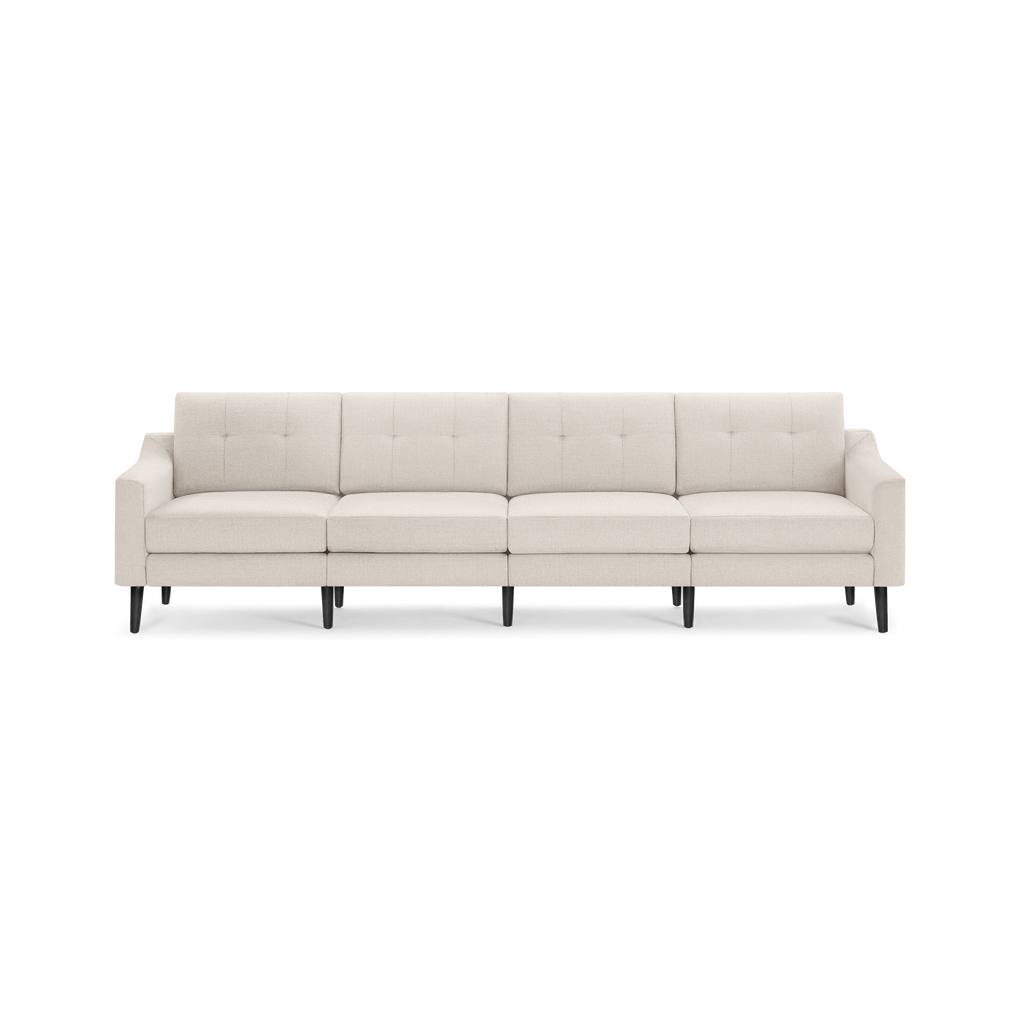 Modern beige four-seat sofa with tufted back cushions, slim armrests, and dark wooden legs on a transparent background.