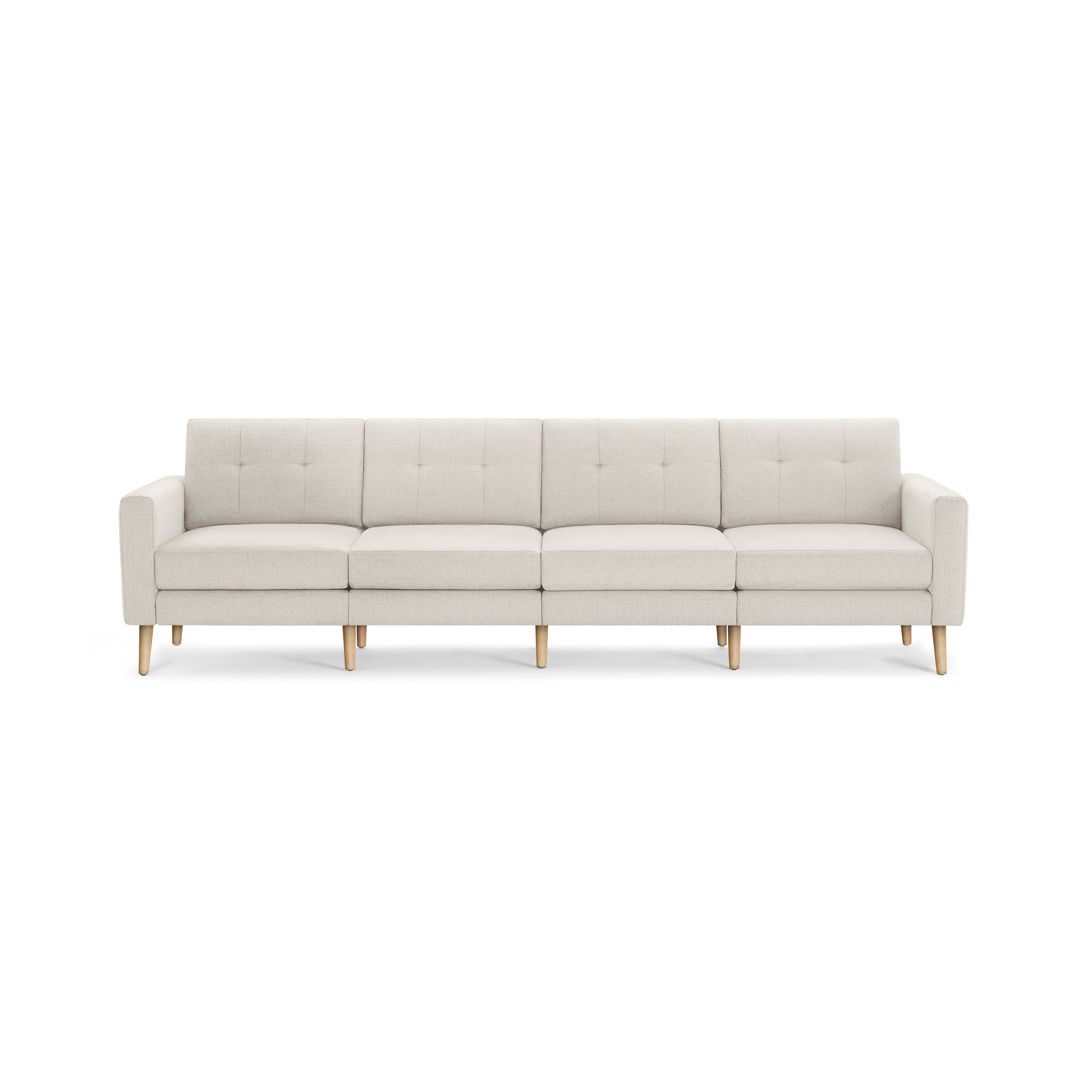 Cream-colored modern four-seat sofa with tufted back cushions and wooden legs on black background.