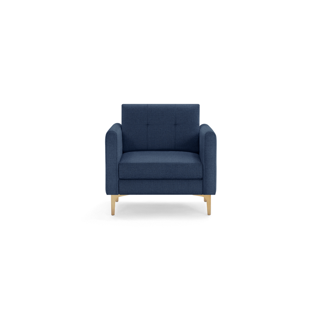 Front view of a modern navy blue upholstered armchair with tufted backrest and light wooden legs on a black background.