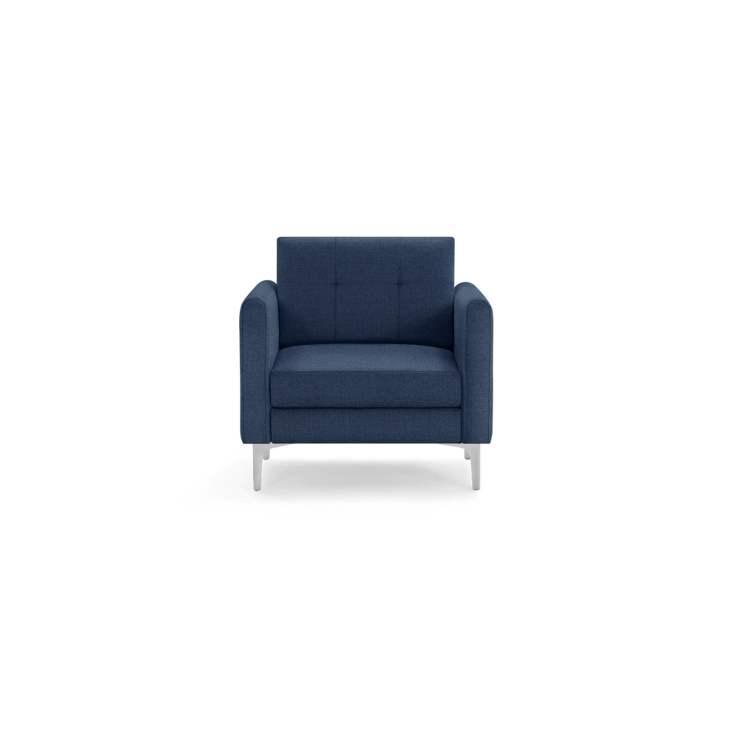 Modern deep blue fabric armchair with square tufted backrest, thick cushioned seat, and angled silver metal legs.