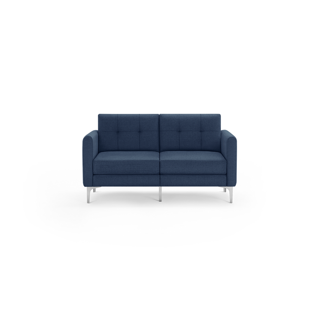 Modern two-seater sofa in dark blue fabric with tufted backrest and sleek silver metal legs.