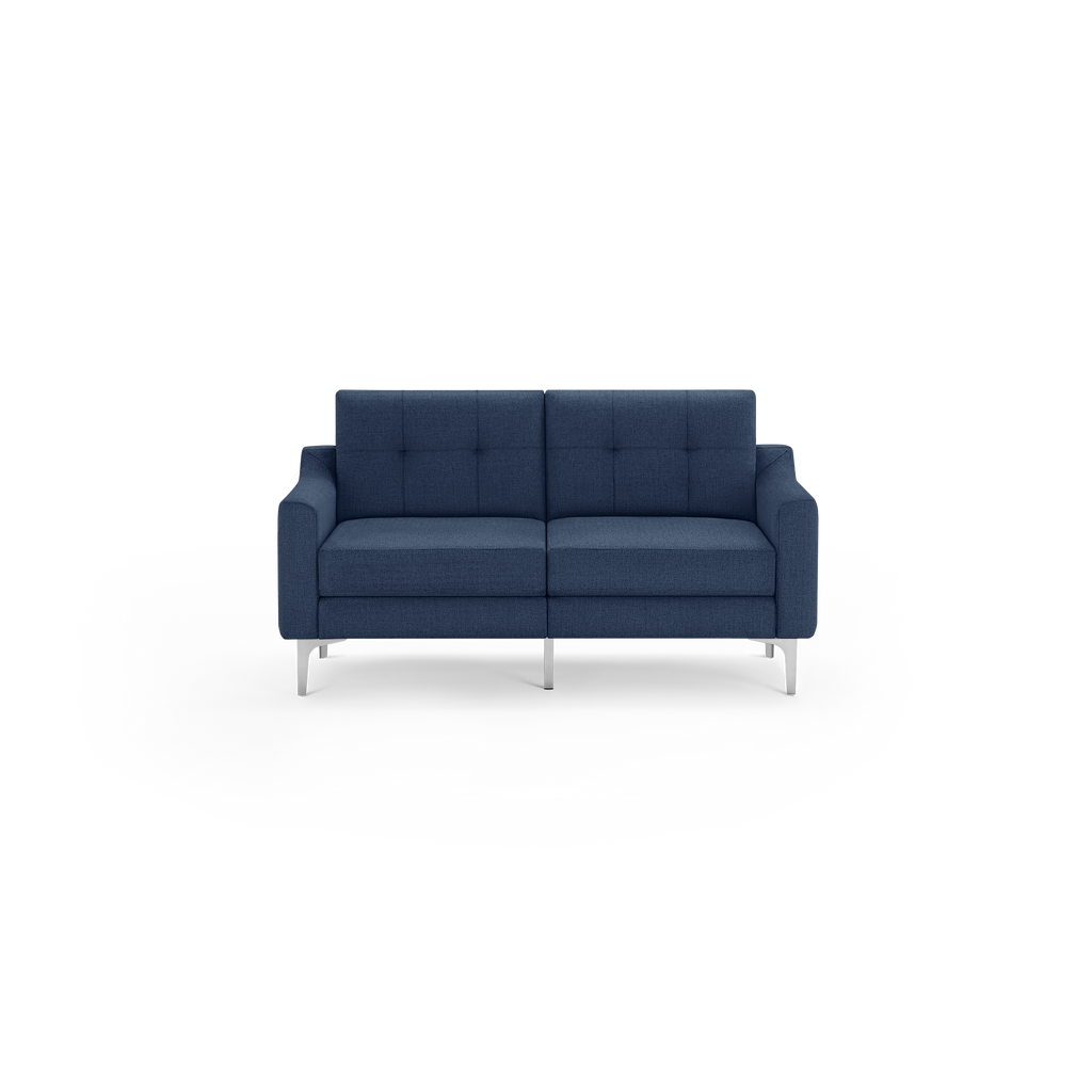 Contemporary navy blue fabric loveseat with tufted back cushions and sleek silver metal legs against a black background.