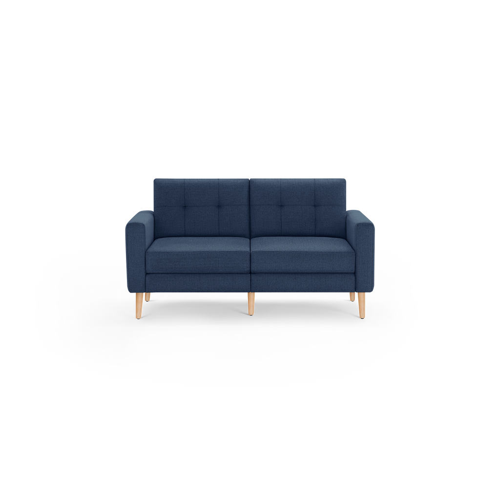 Mid-century modern navy blue fabric loveseat sofa with tufted back cushions and light wooden legs on a black background.