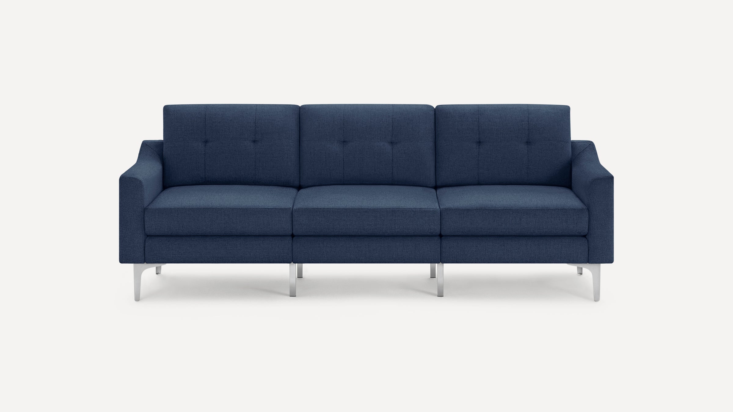 Three-seater modern navy blue upholstered sofa with button-tufted back cushions and slim metal legs on white background.