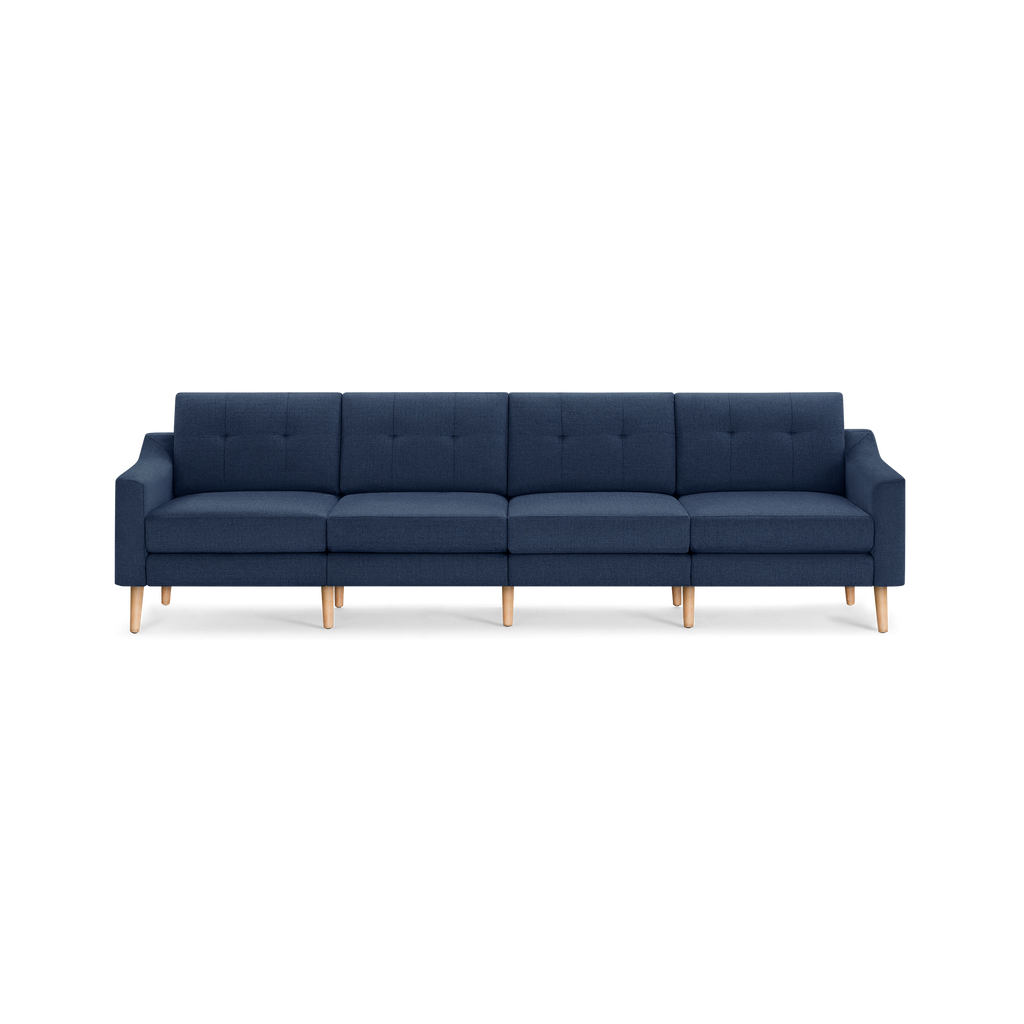 Modern navy blue four-seater sofa with tufted back cushions and light wooden legs, featuring a sleek and minimalist design.