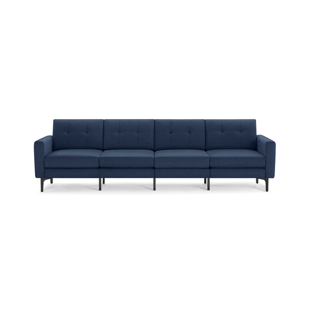 Modern navy blue fabric four-seater sofa with button-tufted backrest, slim armrests, and black metal legs on a transparent background.
