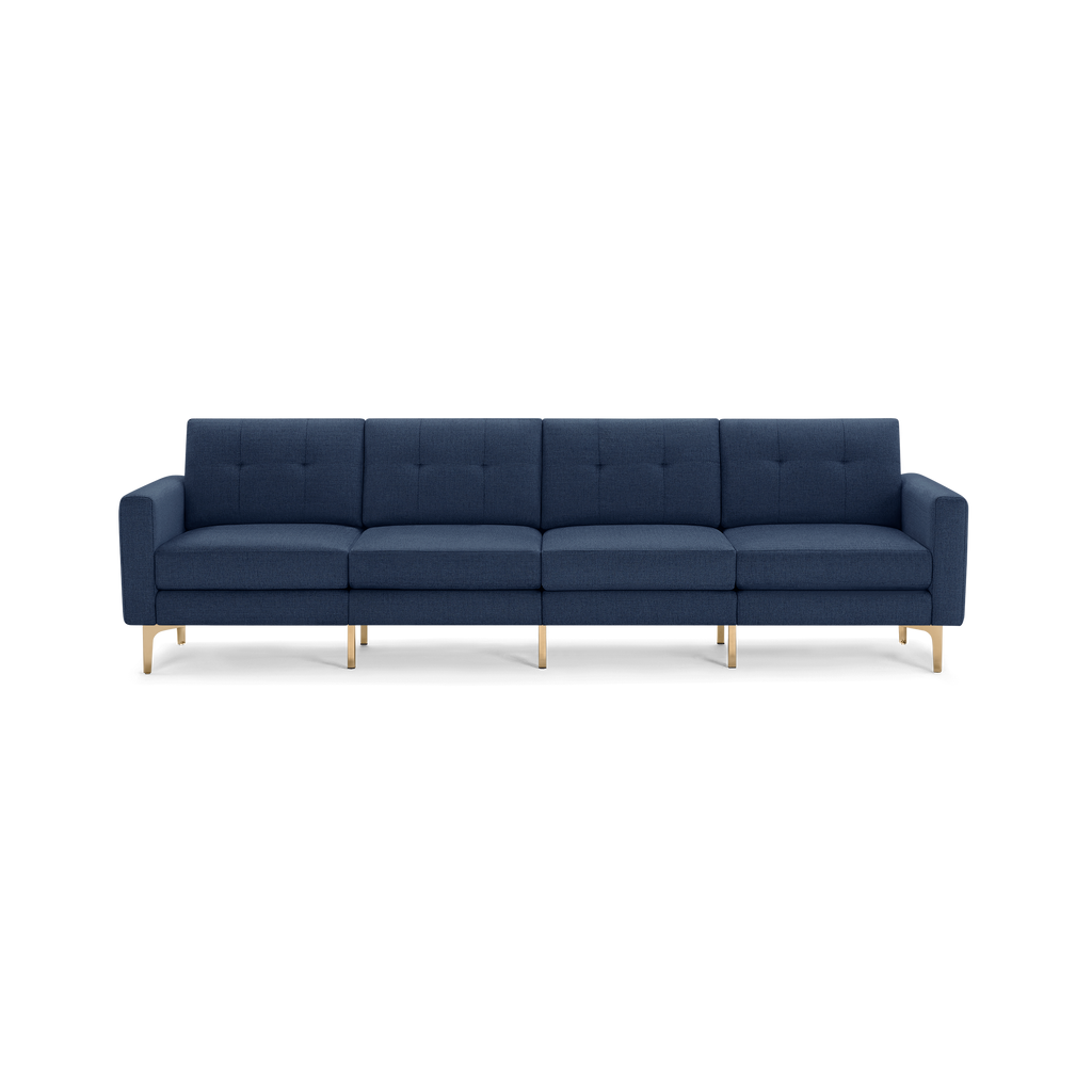 Modern mid-century style four-seater sofa with navy blue tufted fabric upholstery and gold metal legs on a black background.