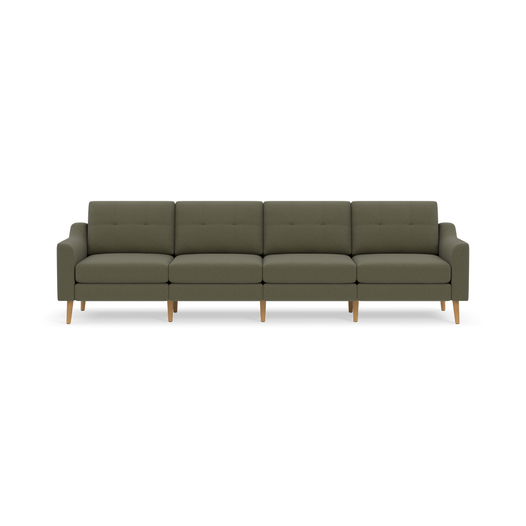 Modern four-seater sofa in muted green upholstery with wooden legs and simple tufted backrest cushions on a black background.