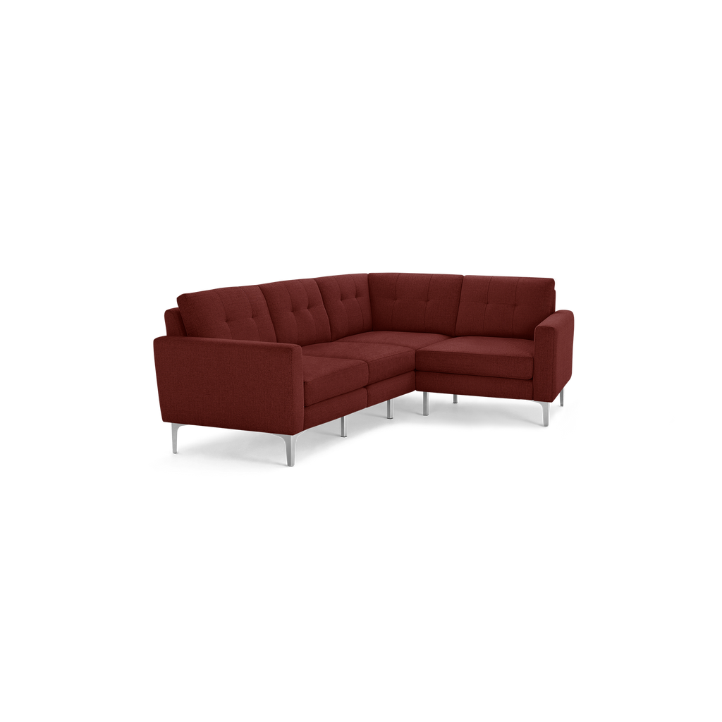 Modern L-shaped sectional sofa in deep burgundy fabric with tufted cushions and slim silver metal legs, designed for contemporary living spaces.