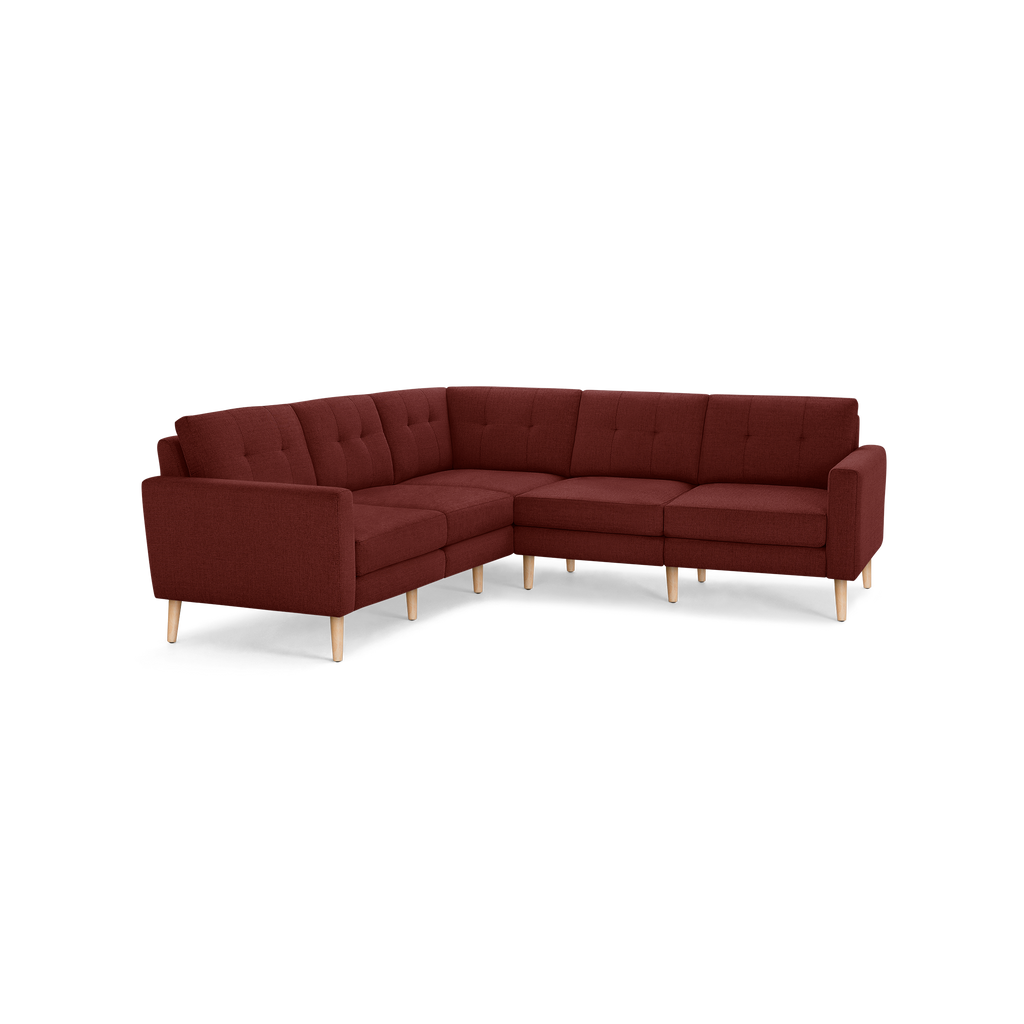 L-shaped sectional sofa with tufted back cushions, upholstered in deep reddish-brown fabric, and supported by light wooden legs.