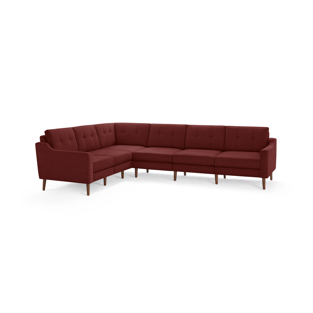 Large L-shaped sectional sofa upholstered in deep red fabric with tufted back cushions and wooden legs.