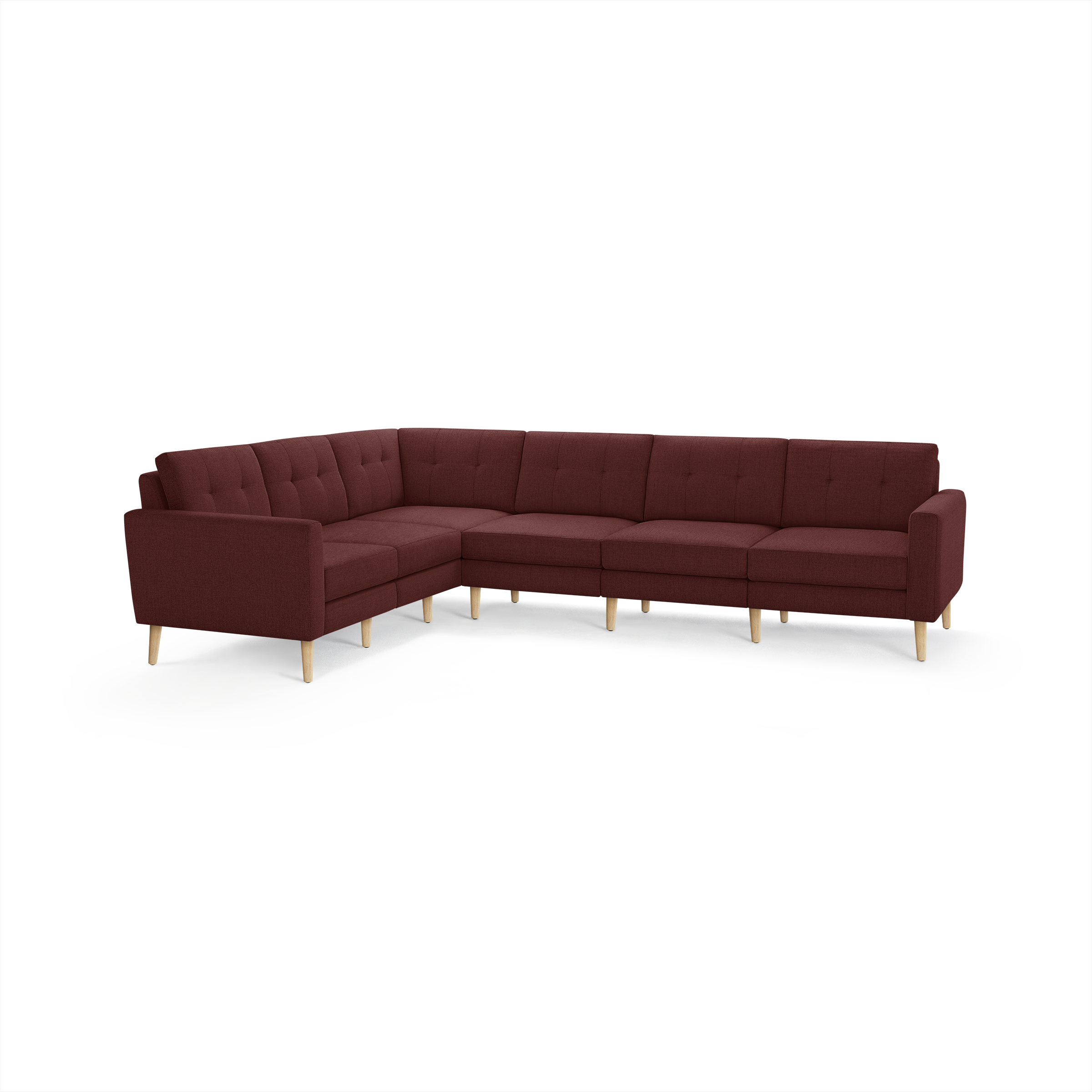 Large L-shaped sectional sofa in deep burgundy fabric with tufted cushions and light wooden legs, modern mid-century design.