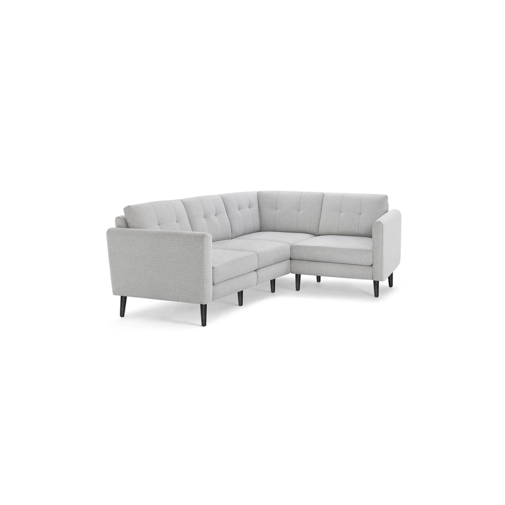 Light gray fabric mid-century modern sectional sofa with tufted back cushions and black tapered wooden legs.
