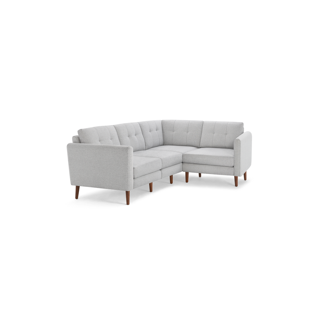 Modern light gray sectional sofa with tufted back cushions and wooden tapered legs, designed for corner placement and comfortable seating.