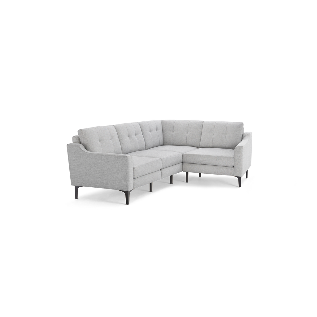 Light gray L-shaped sectional sofa with tufted back cushions and slim black metal legs.