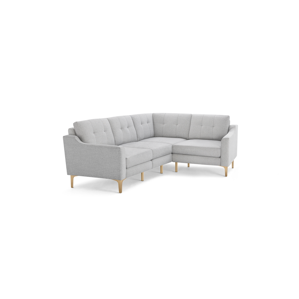 Light gray L-shaped sectional sofa with tufted back cushions and slim wooden legs, featuring modern design and clean lines.