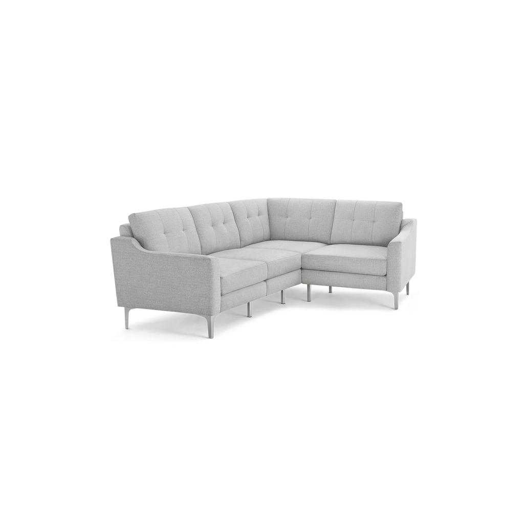 Light gray L-shaped sectional sofa with tufted back cushions, slim arms, and metal legs, modern and minimalist design.