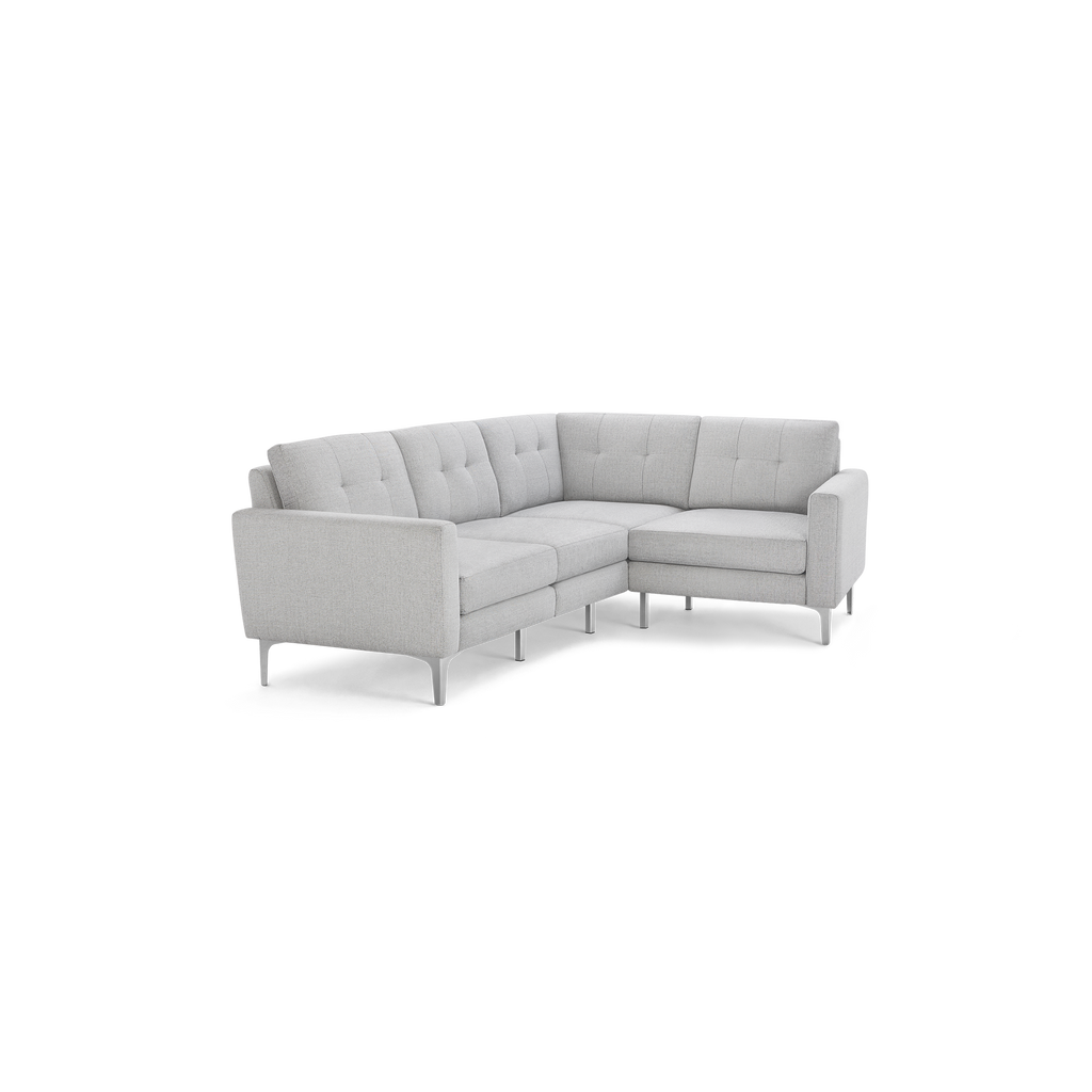 Light gray modern L-shaped sectional sofa with tufted back cushions, slim armrests, and metal legs on black background.