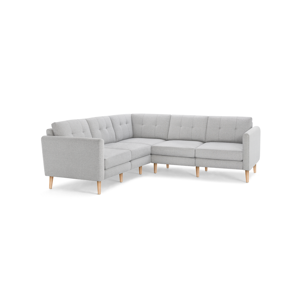 Light gray L-shaped sectional sofa with tufted back cushions and wooden tapered legs.