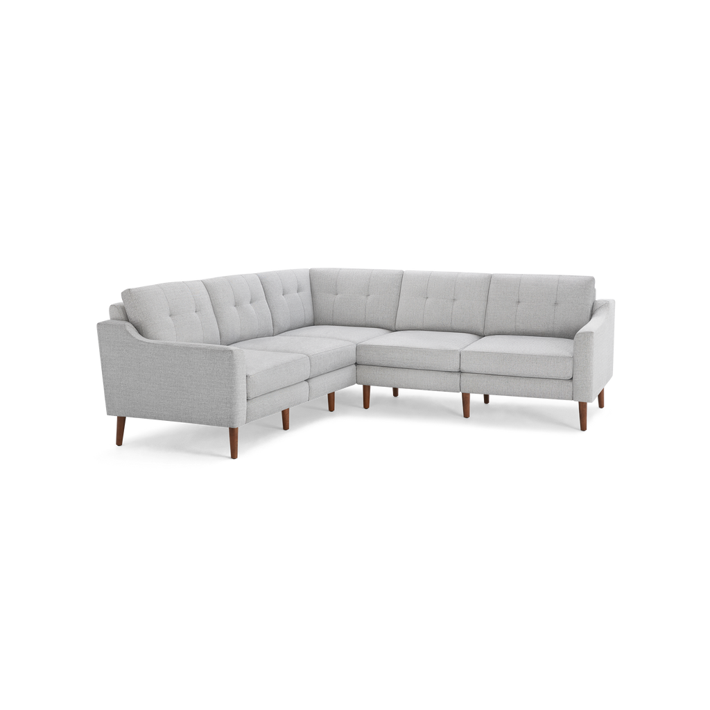 Light gray fabric L-shaped sectional sofa with tufted back cushions and wooden tapered legs.