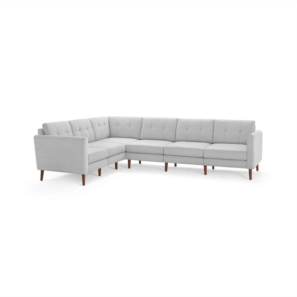 Light gray L-shaped sectional sofa with tufted back cushions and wooden legs, designed for modern living spaces.