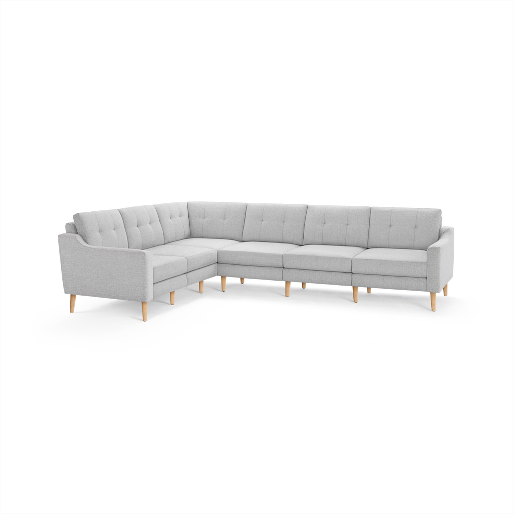 Light gray L-shaped sectional sofa with tufted back cushions and wooden legs, featuring a modern and minimalist design.