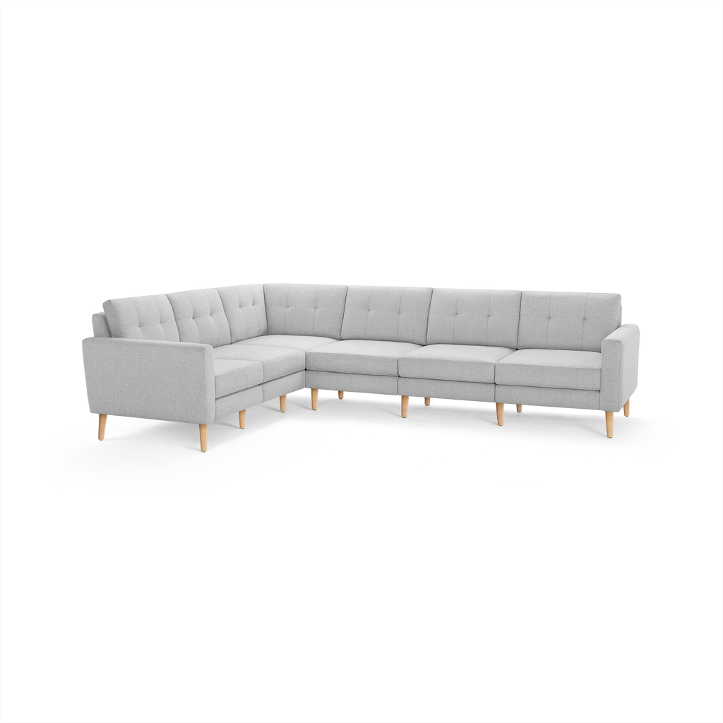 Light gray L-shaped sectional sofa with tufted back cushions, wooden tapered legs, and modern minimalist design.