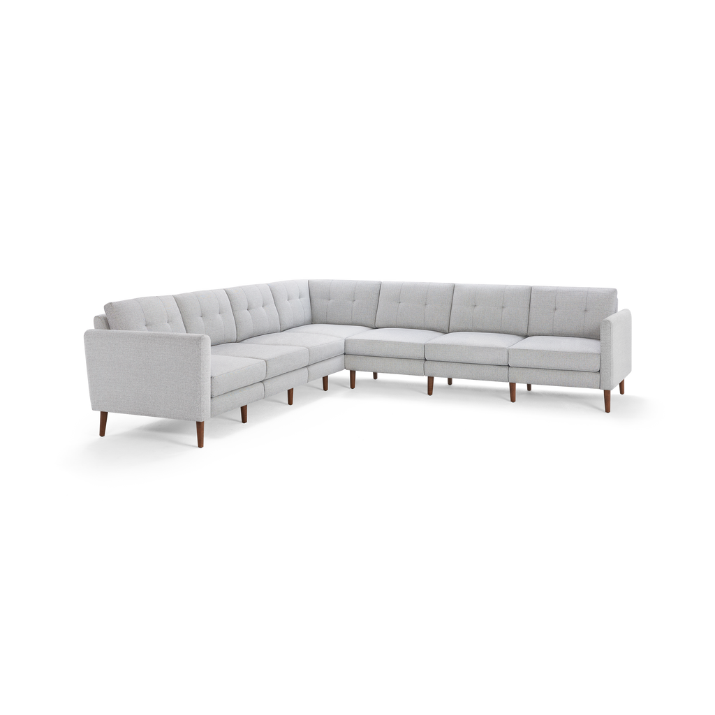 Light gray fabric upholstered L-shaped sectional sofa with tufted back cushions and wooden tapered legs.