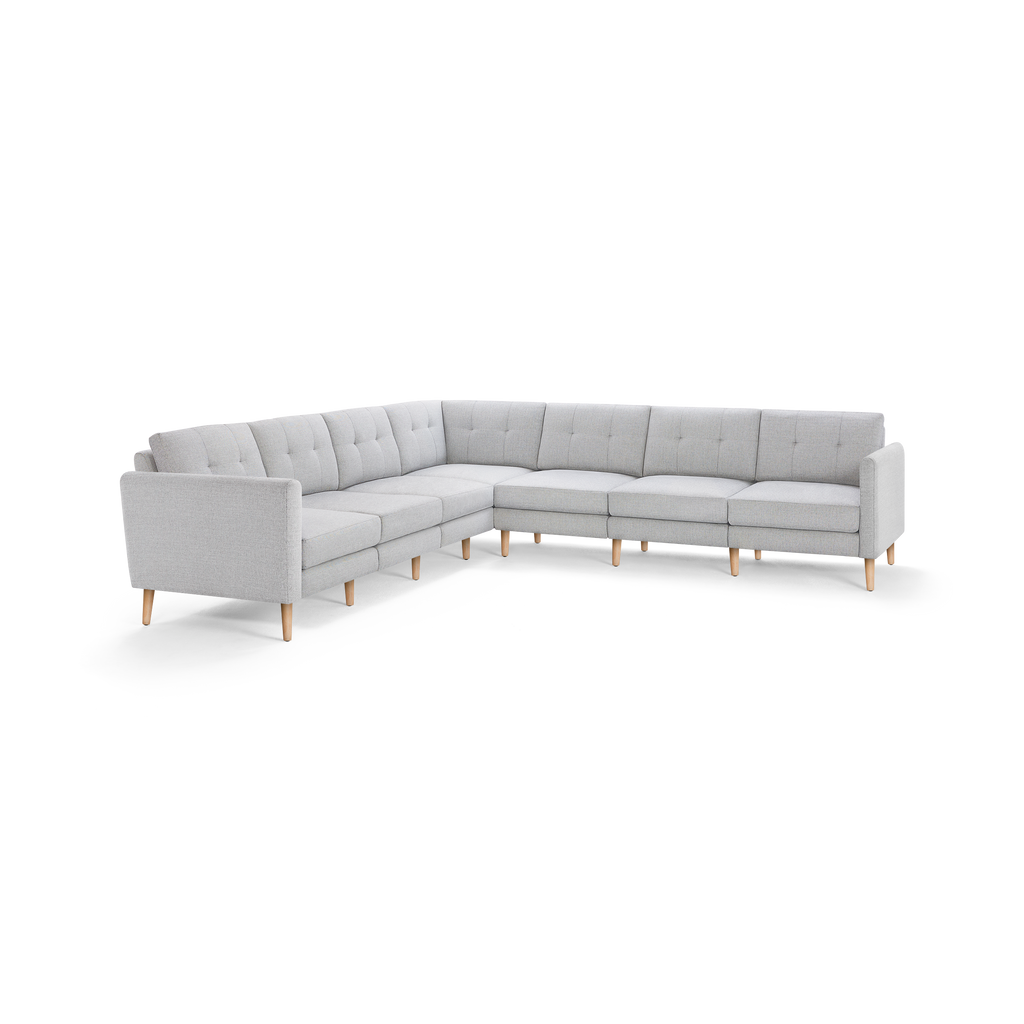 Light gray L-shaped sectional sofa with tufted back cushions and wooden tapered legs, modern and spacious design.