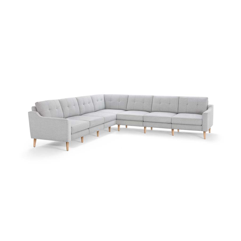 Light gray L-shaped sectional sofa with tufted back cushions and wooden legs, modern and minimalist design.