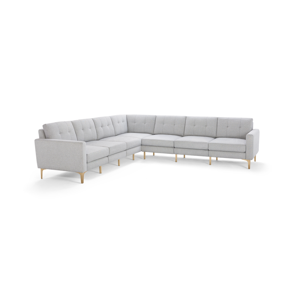 Light gray L-shaped sectional sofa with tufted cushions, slim armrests, and wooden legs, designed for modern living spaces.