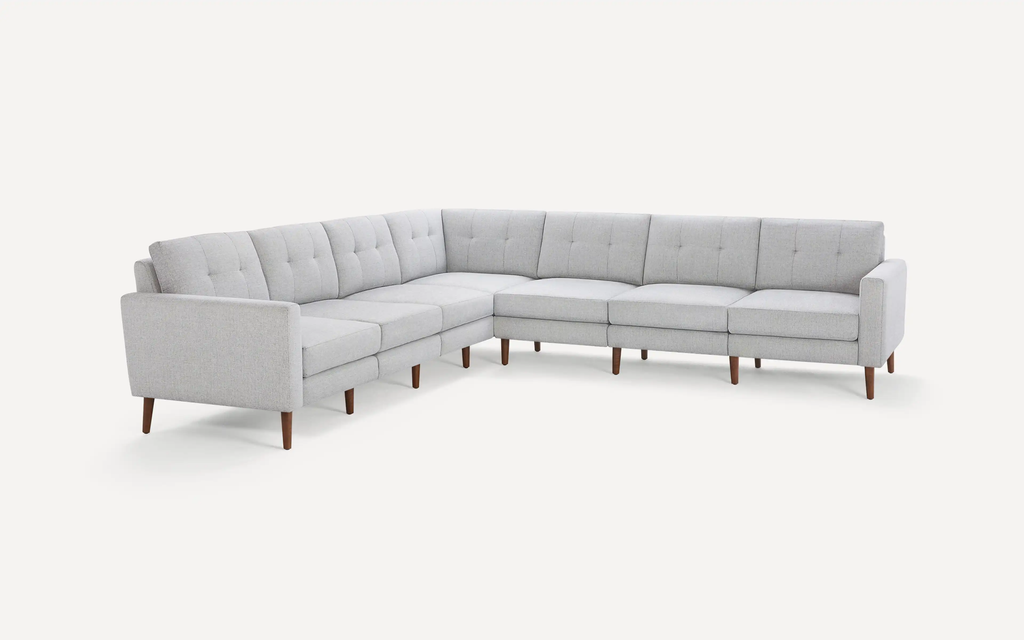 modern light gray fabric sectional sofa with tufted back cushions and wooden legs, featuring a clean, minimalist design