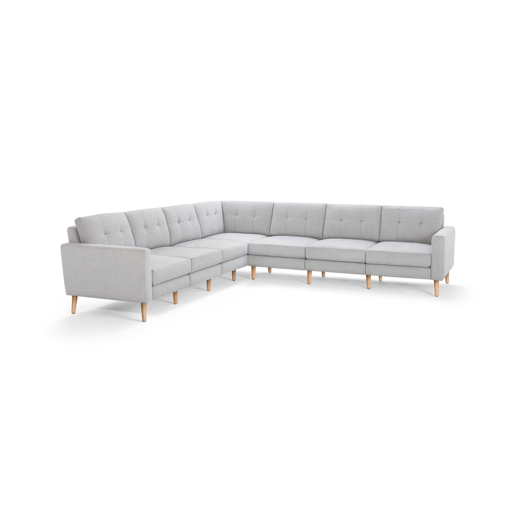Light gray L-shaped sectional sofa with tufted cushions and wooden legs, featuring clean lines and modern design.