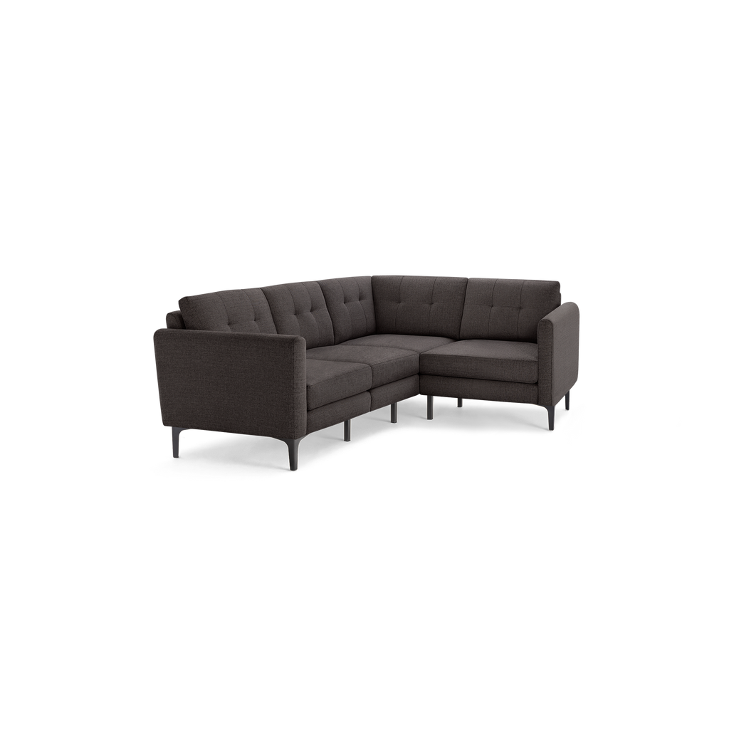 Modern dark gray fabric L-shaped sectional sofa with tufted back cushions and slim black metal legs.