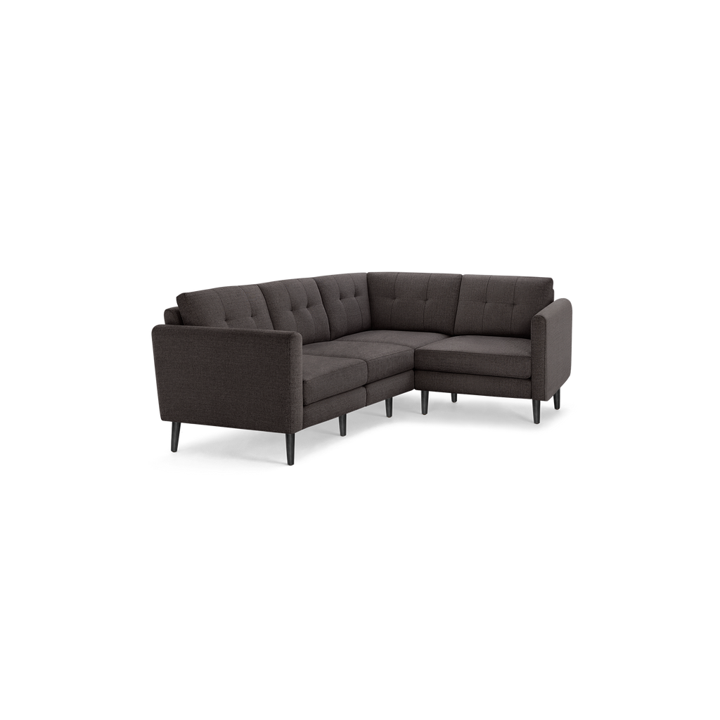 Dark gray fabric L-shaped sectional sofa with tufted back cushions and slim black wooden legs.