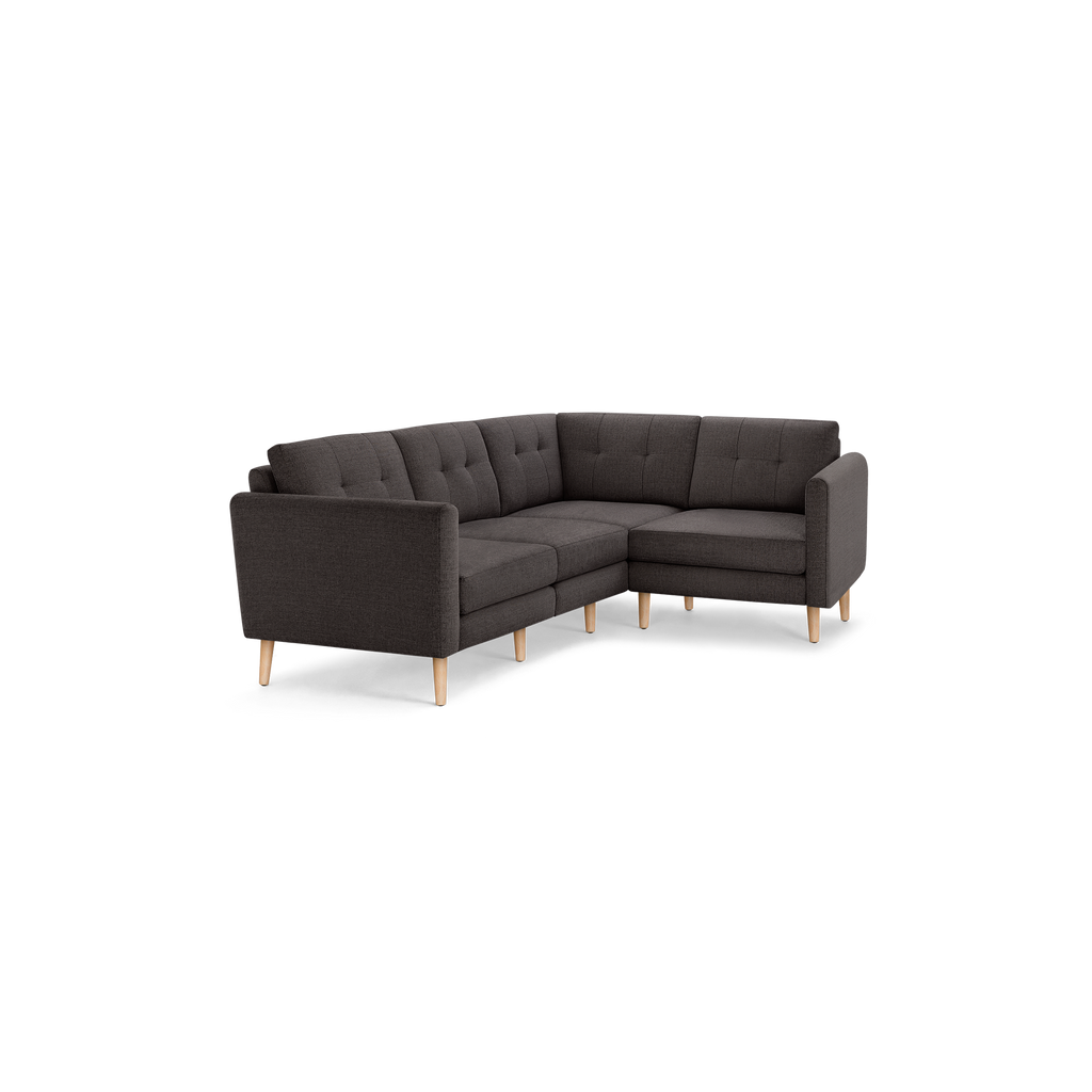 Dark gray L-shaped sectional sofa with tufted cushions and light wooden legs, designed for modern living rooms.