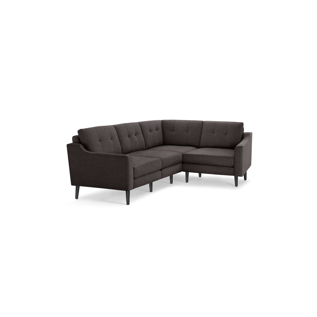 Dark gray upholstered L-shaped sectional sofa with tufted back cushions and black tapered legs.