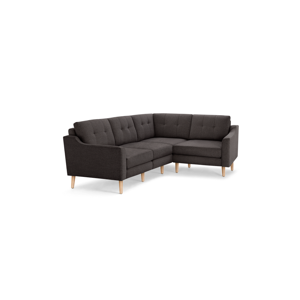 Dark gray fabric L-shaped sectional sofa with tufted back cushions and light wooden legs, offering modern style and comfort.